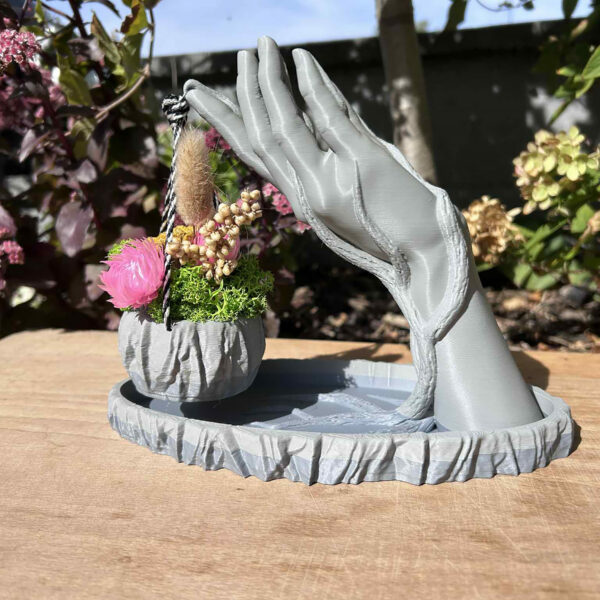 Hand met mandje gevuld met droogbloemen.